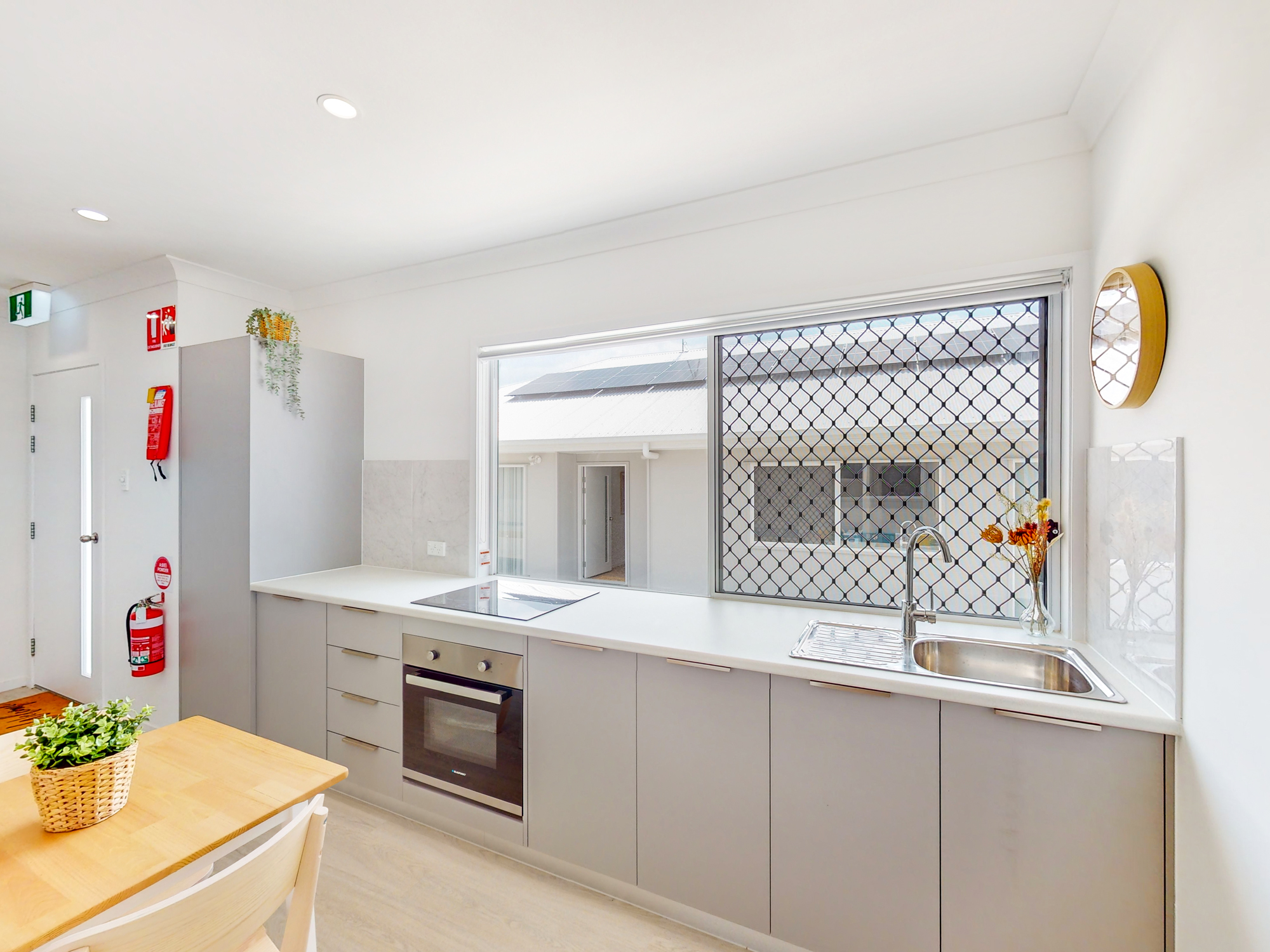 Modern shared kitchen with light cabinetry and natural light.