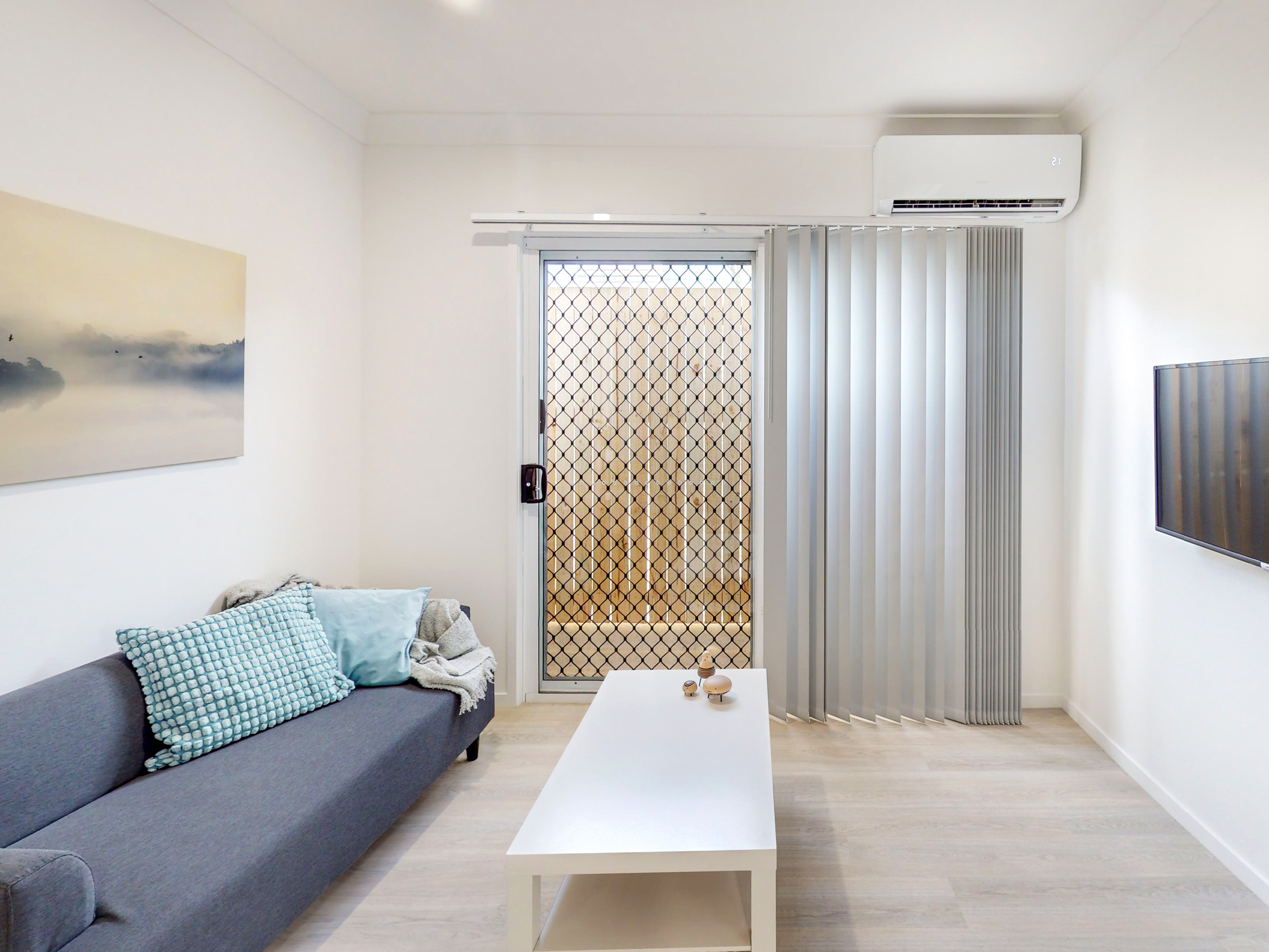 Private studio living area with sofa and garden outlook.